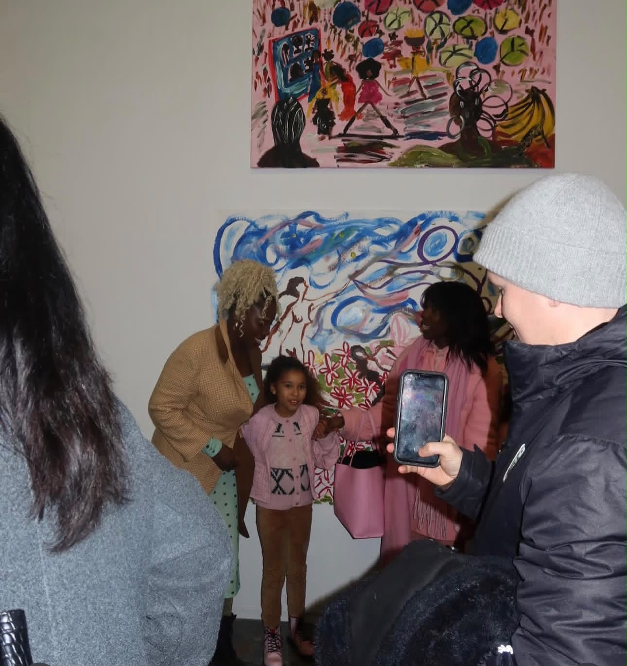 Visitors gathered in front of the paintings